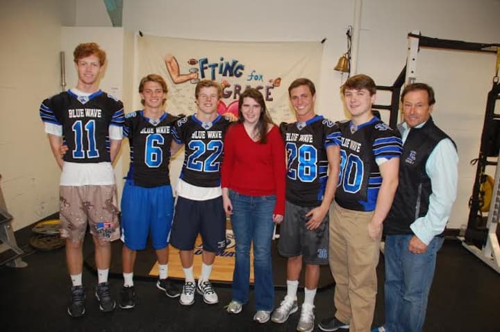 From left, Darien football captains Tim Graham, Colin Minicus, Hudson Hamill, Grace Wohlberg, Bobby Trifone, Mark Evanchick and Darien football oach Rob Trifone get ready for &quot;Lifting Grace.&quot; Missing is: Christian Trifone.