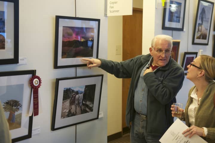 Visitors view photos at the Wilton Arts Council exhibit.