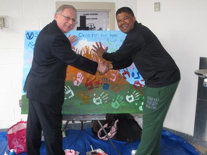 From left, Westchester County Chief of Staff George Oros and St. Christophers, Inc. Kurt Kannemeyer make painted hand marks on the art canvas during the pep rally to support Kannemeyers upcoming Mount Kilimanjaro climb in Tanzan.