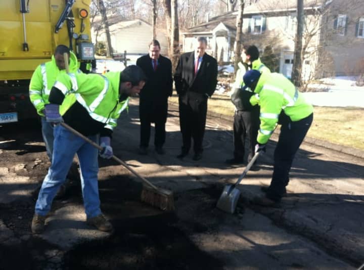 City workers, from left, Hanlet Castillo, Aaron Turner, and Joseph Coplon, clean out a pothole before its filled with hot asphalt as Mayor David Martin looks on. March 31-31 has been dubbed &quot;Pothole Week&quot; by the city.
