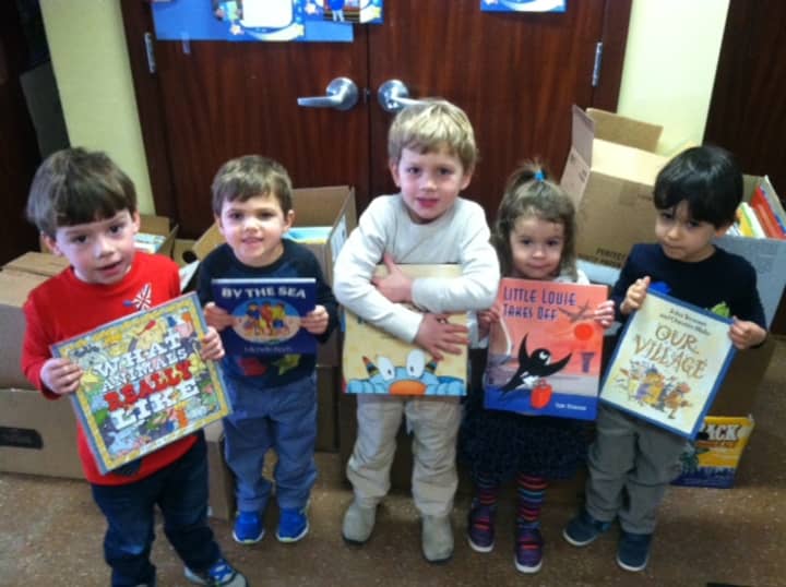 Children at Westport Weston Cooperative Nursery School show books the organization donated to Read To Grow.