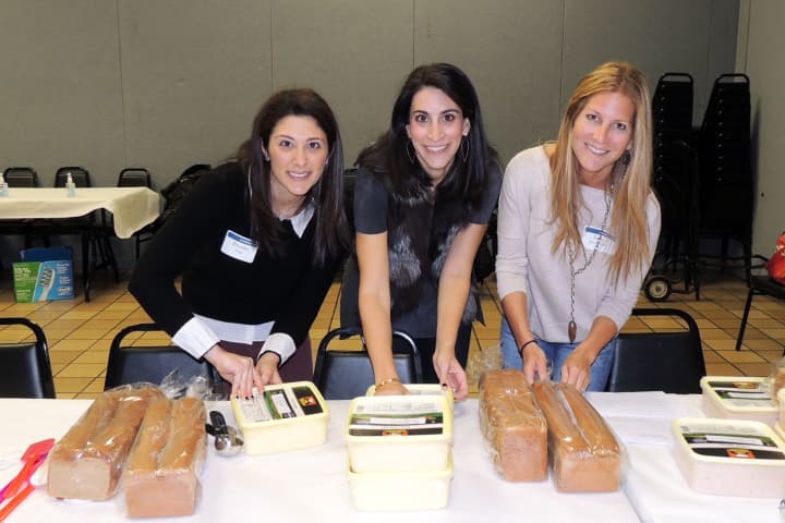 From left, event chairs Brooke Fina, Leslie Perelman, and Jodi Boockvar prepare sandwiches for donation.