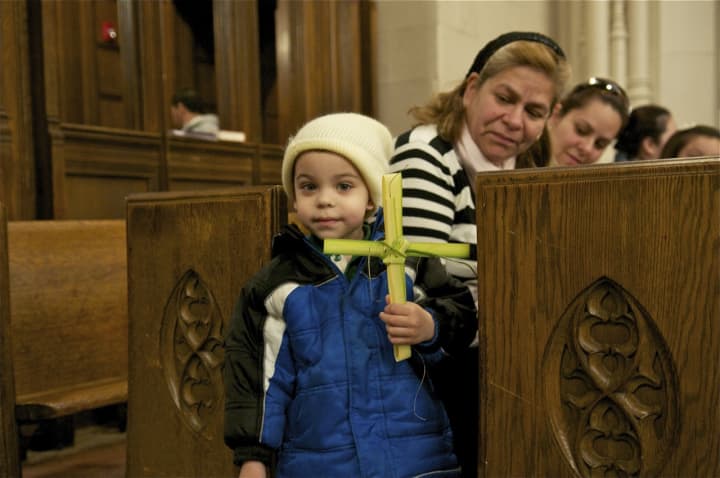 A young boys holds his palm cross at St. Mary&#x27;s on Palm Sunday.