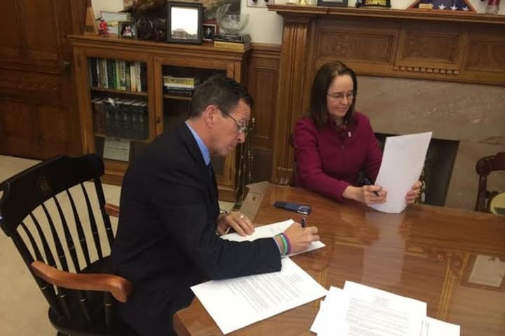 Connecticut Gov. Dannel Malloy signs the executive order Monday in his office. 
