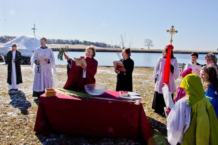The Rev. Peggy Hodgkins performs the blessing of the palms on Sunday, March 29, on Perry Green at the Southport Harbor.