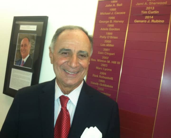 Genaro J. (Gene) Rubino stands between his photograph and the name of he and the recipients of Citizen of the Year. Rubino will be honored at the Citizen of the Year dinner on April 28. 