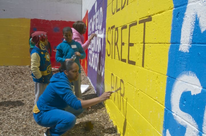 Students paint murals at the Cedar Street Park in Stamford.