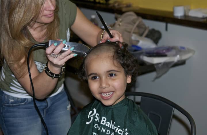 A Yonkers Montessori School student gets his head shaved for charity.