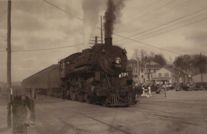 Depicted is a steam locomotive train passing through Bedford Hills in the early 1930s.