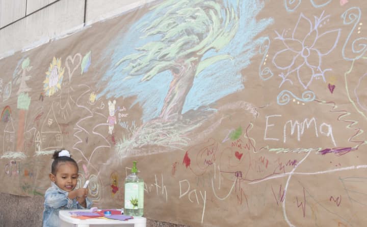 Saelis Garcia, 3, draws on recycled paper lining Macy&#x27;s for an Earth Day event in White Plains