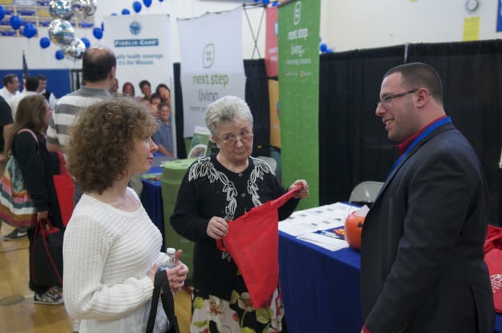 A business exhibitor greets visitors at the Shop Putnam Business and Home Expo.