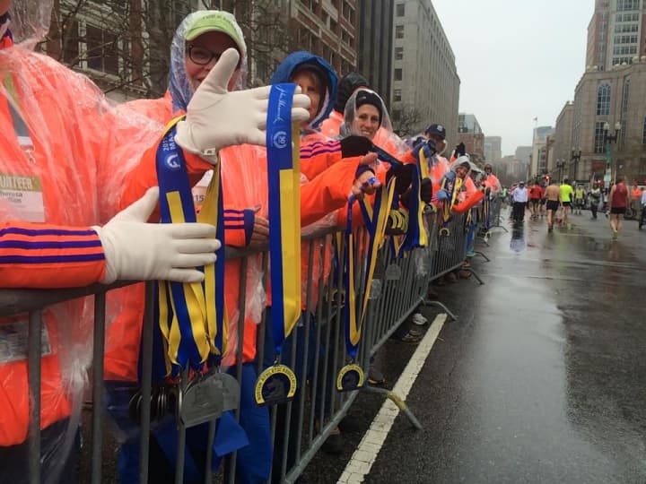 Volunteers wait to distribute finishers medals to runners at Monday&#x27;s Boston Marathon.