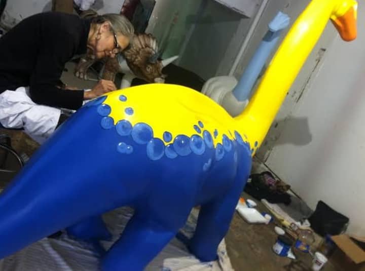 Barbara Post Campbell paints her dinosaur during an open house at the artists studio. 