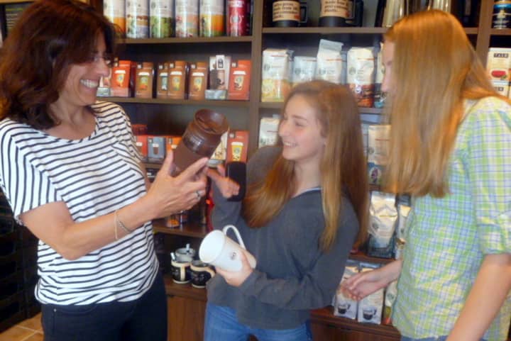 Vicki Weisman, left, checking out coffee mugs at reopened Starbucks with daughters, Natalie, middle and Charlotte