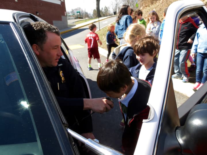 Detective Paul Camilleri lets students hear their voices through the police car loud speakers,