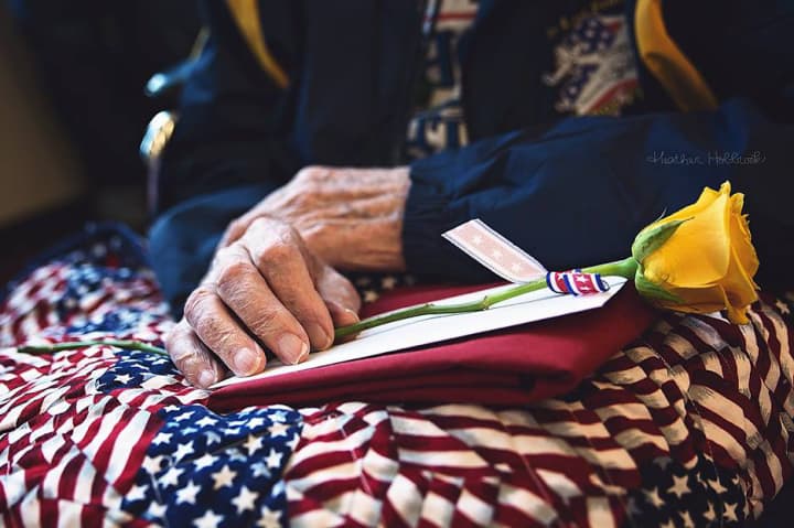A military veteran holds his quilt made by volunteers supporting Quilts of Valor.