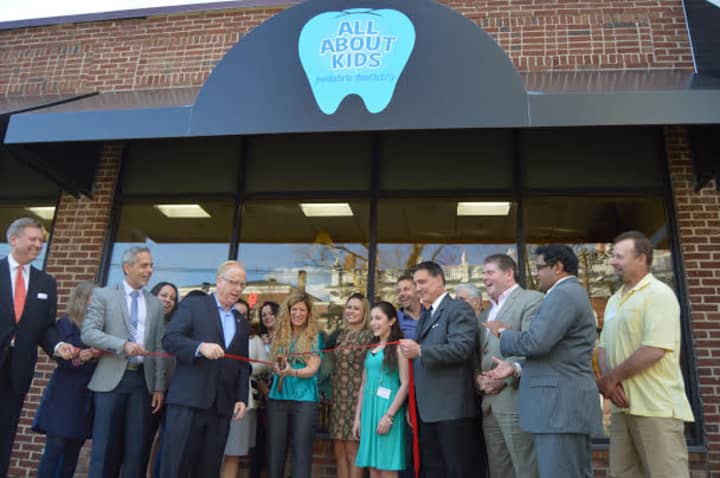 Danbury Mayor Mark Boughton cuts the ribbon at the grand opening for All About Kids dentistry on West Street. 