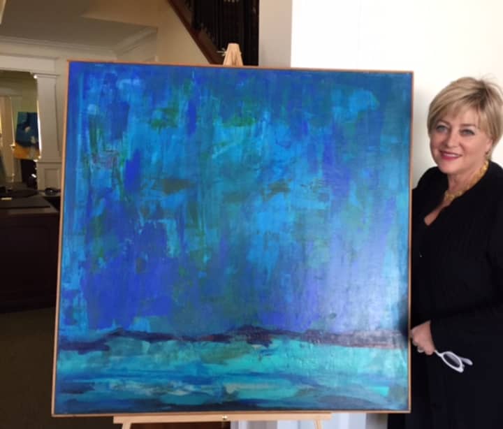 Jane Ubell-Meyer poses with one of her paintings.