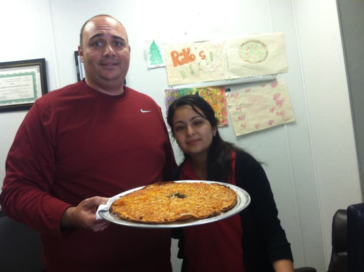 Co-owner Luigi Cardillo Jr., of Riko&#x27;s Pizza, and Assistant Manager Maribel Aquino with one of their hot oil pizzas.