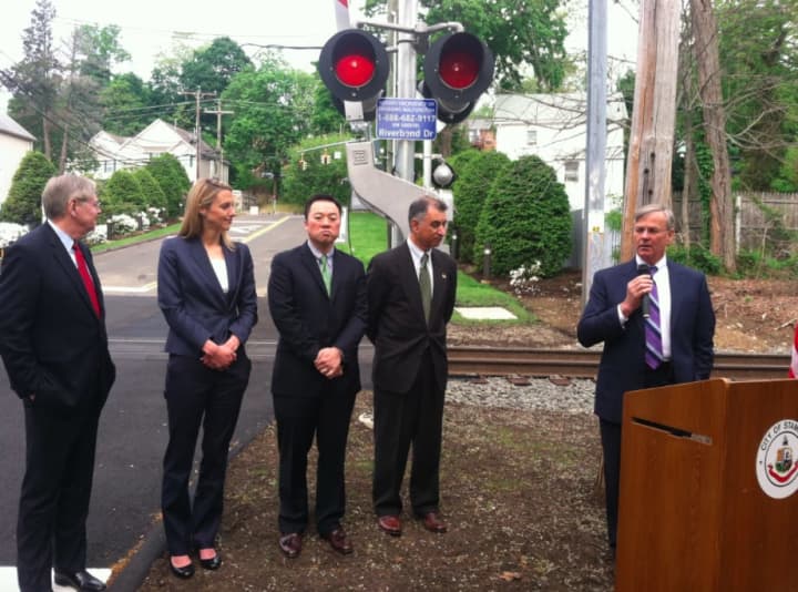 DOT Commissioner James Redeker speaks while from left: Mayor David Martin, state Reps. Caroline Simmons and William Tong and state Sen. Carlo Leone look on during an announcement heralding safety improvements at the Riverbend rail crossing.