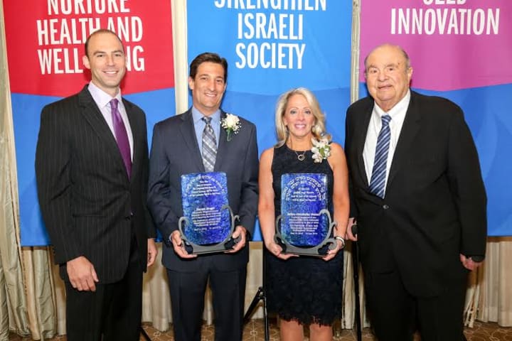 Jason Friedland of Scarsdale, left, presents a UJA Federation award to Daniel Singer, co-president of Robison Oil. Debra Abrahams Weiner, second from right, receives an award from her presenter, the Honorable Samuel G. Fredman of White Plains
