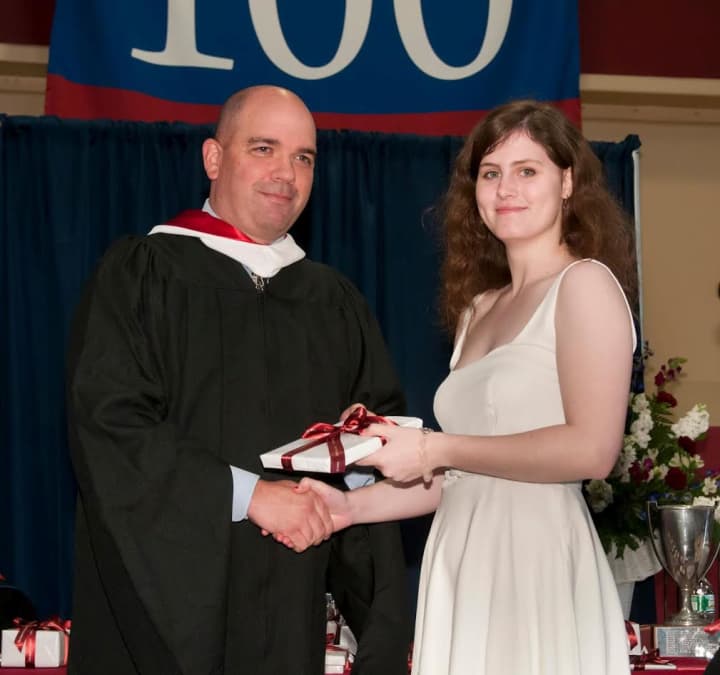 Harvey Upper School Head Phil Lazzaro, left, presents Mary Nichols of Greenwich with one of the five major academic prizes she received at the Katonah, N.Y. schools graduation ceremony.