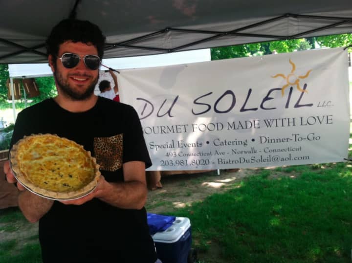 Bobby Goelz, of Du Soleil, holds a quiche at Wednesday&#x27;s Wilton Farmers Market.