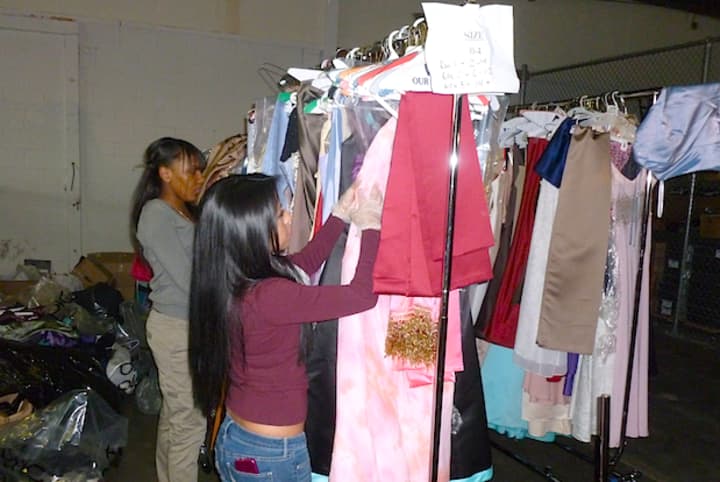 Student members of Operation Prom organize racks of dresses and other formal wear at the organization&#x27;s warehouse in Elmsford.