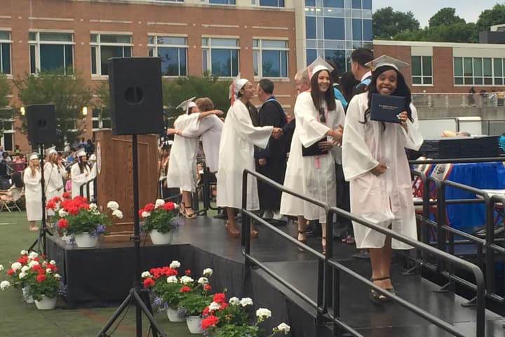 Brien McMahon High School seniors receive their diplomas upon graduating Wednesday.
