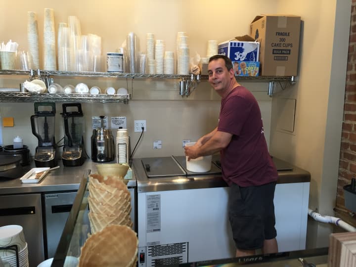 Village Creamery Owner John Caldarola scooping ice cream.