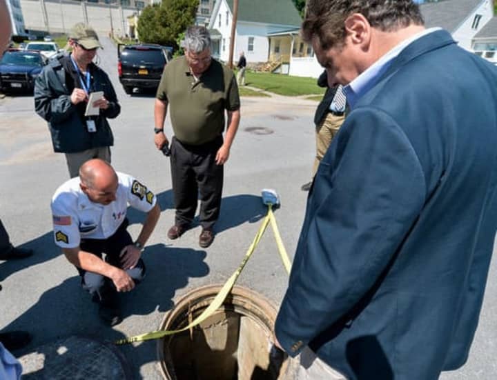 Gov. Andrew Cuomo examines the manhole prison escapees Richard Matt and David Sweat climbed out from on June 6.
