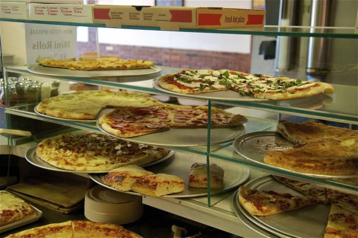 Several styles of pizza on display.