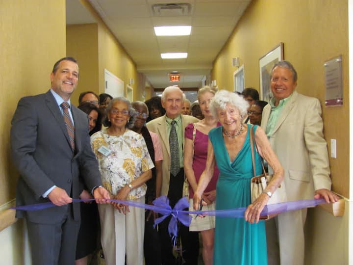 Wilma Harris cuts the ribbon at a room named after parents, August and Martha Moebus Uebel, at Wartburg in Mount Vernon. 