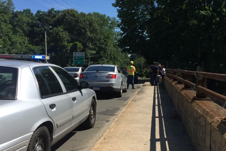 Officials interview witnesses on the Scribner Avenue bridge in Norwalk where a woman reportedly jumped onto I-95.