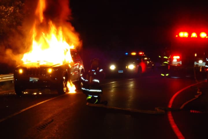 Norwalk firefighters extinguish a burning car on the Exit 15 northbound ramp to the Route 7 Connector Wednesday night.