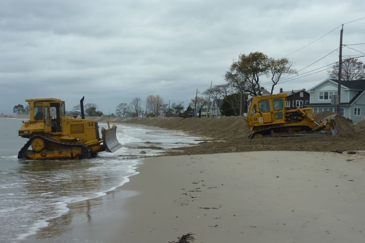 Bulldozers create a wall of sand along Compo Beach in Westport Sunday in anticipation of the high ways expected with Hurricane Sandy. 