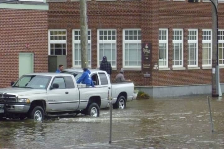 Trucks drive carefully through a flooding parking lot in Irvington.