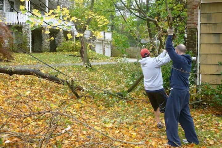 John Soler and Adam Nadborny, residents of Greenacres Avenue in Hartsdale, move a tree that fell down in their neighbor&#x27;s yard.