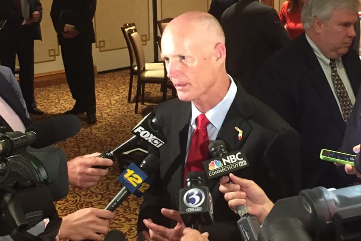 Florida Gov. Rick Scott talks to reporters after addressing a roundtable group of business leaders at the Norwalk Inn Friday.