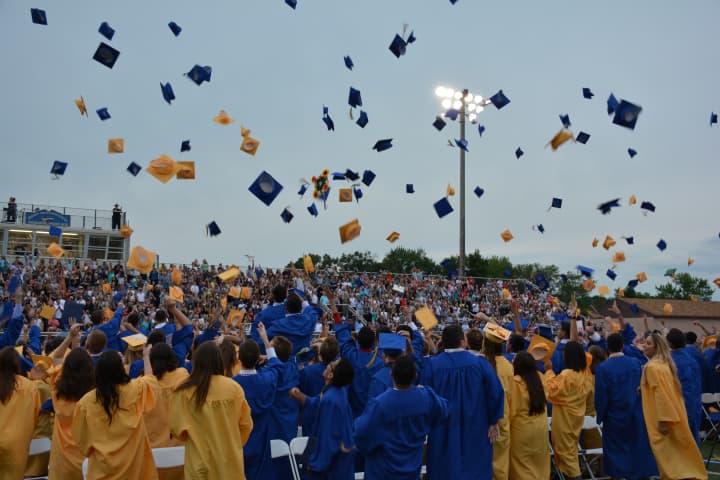 Newly minted Mahopac High School graduates throw their mortarboards in the air to celebrate.