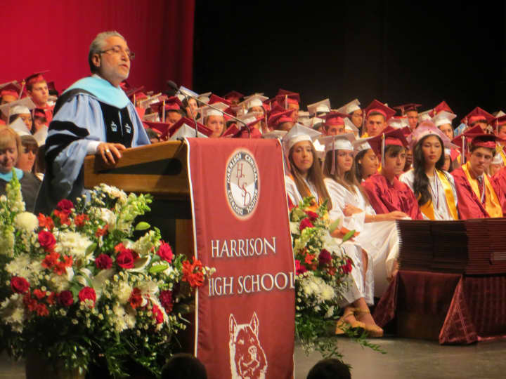 Harrison Superintendent Louis N. Wool speaking to high school graduates, family and friends last spring during commencement at SUNY Purchase. On Tuesday, Harrison voters approved the school district&#x27;s $110 million budget for 2016-17.