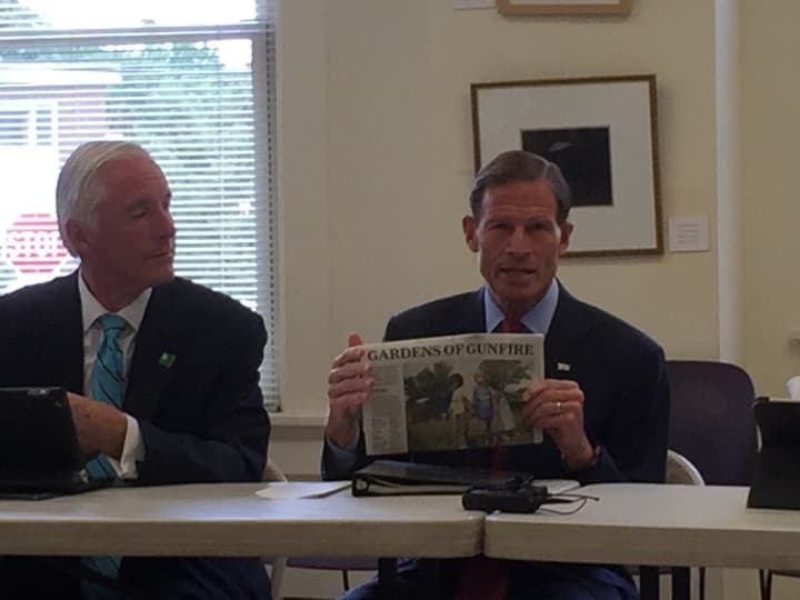 U.S. Sen. Richard Blumenthal (D-Conn.) holds up a newspaper referencing the shooting at a city housing complex this month during a roundtable Monday morning in Bridgeport with Mayor Bill Finch.