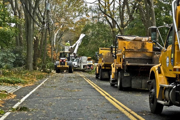 Connecticut Light &amp; Power workers clear a road in Darien following Hurricane Sandy.