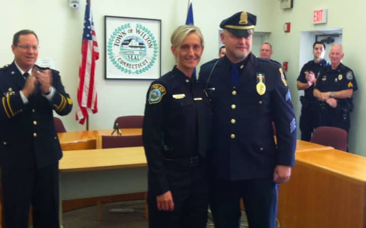 Eva Zimnoch accepts congratulations on being named detective at a ceremony in Wilton on Thursday. Standing with her is her brother Sgt. Lester Zimnoch of the Meriden Police Department. Clapping at left is Interim Police Chief Robert Crosby.