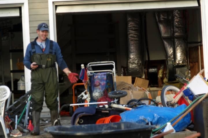 A Fairfield Beach area resident cleans up his flooded house after Hurricane Sandy.
