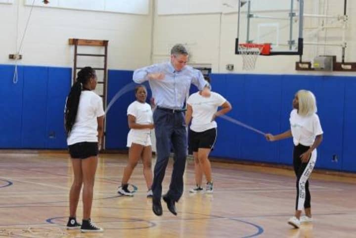 White Plains Mayor Thomas Roach takes a turn jumping on Thursday at Ridgeway Elementary School.