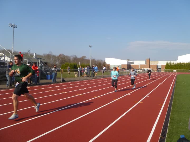 Runners finish the Reservoir Run on the Weston High School track.