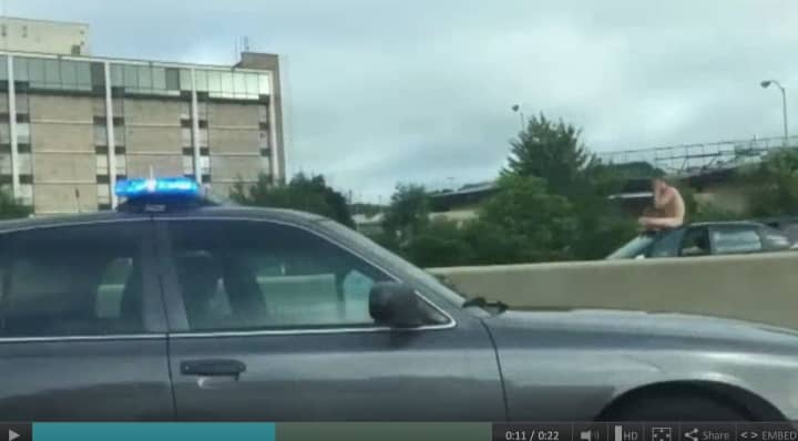 Police stop along I-95 to apprehend a naked man riding atop a car in West Haven. 