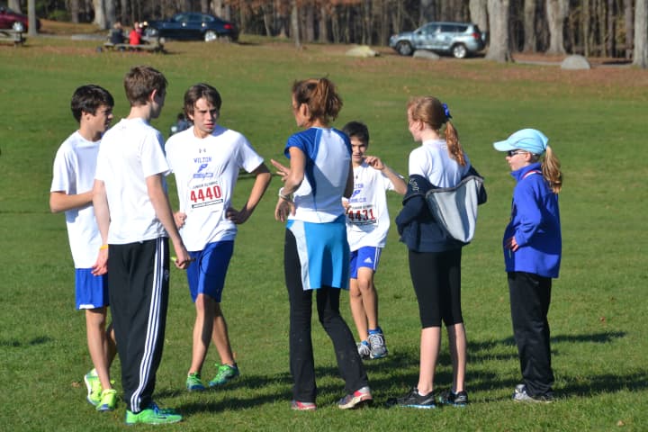 Wilton Running Club coach Mary Zengo talks with runners before the start of the race.