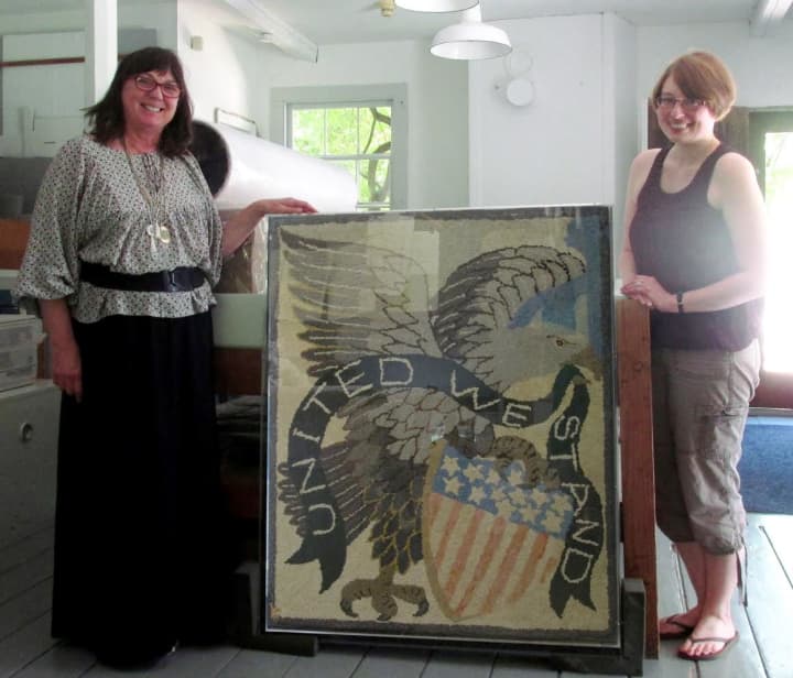 Keeler Tavern Museum Collections curator Erika Askin, left, and textile conservator Meredith Wilcox-Levine pose with the newly restored 19th-century hooked rug at the Textile Conservation Workshop in South Salem, N.Y.